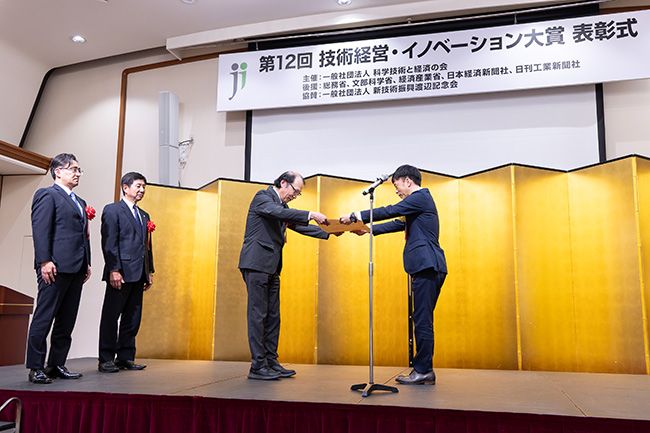 経済産業大臣官房審議官・今村亘氏（右）から賞状を受け取る村上会長（左）